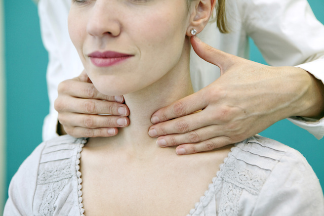 Doctor checking patient's thyroid for Hashimoto's disease.