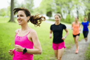 Four women jogging on path