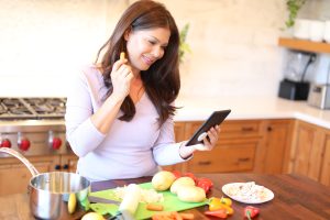 Woman using tablet while preparing food